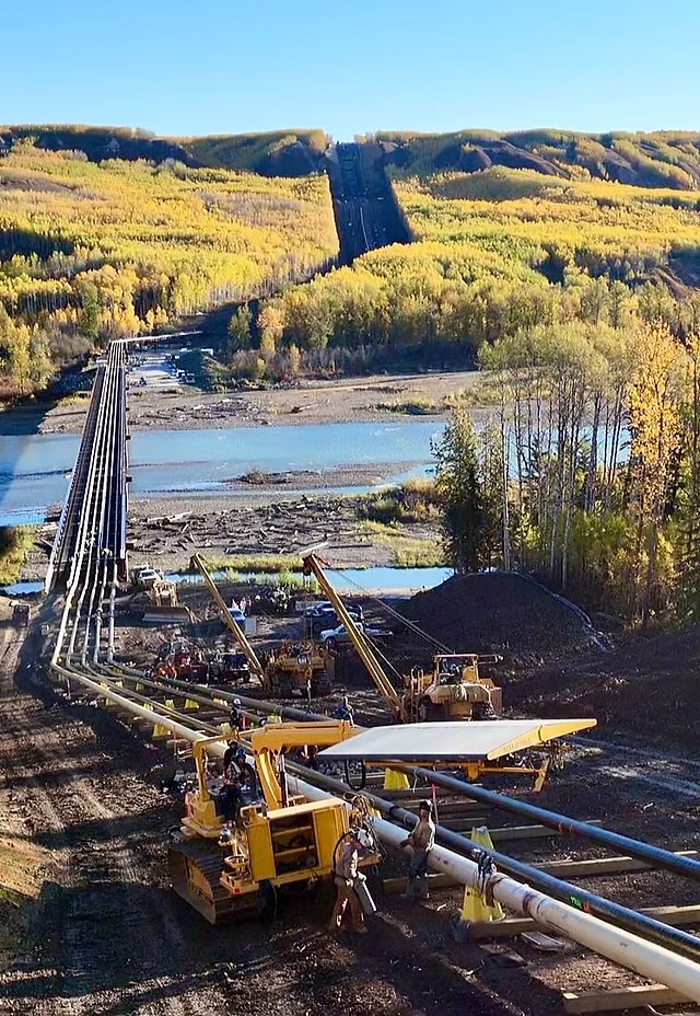 Pipeline construction spread across a river valley